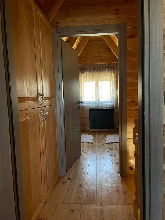 an empty hallway with a door to a room with wood at Snowflake in Žabljak