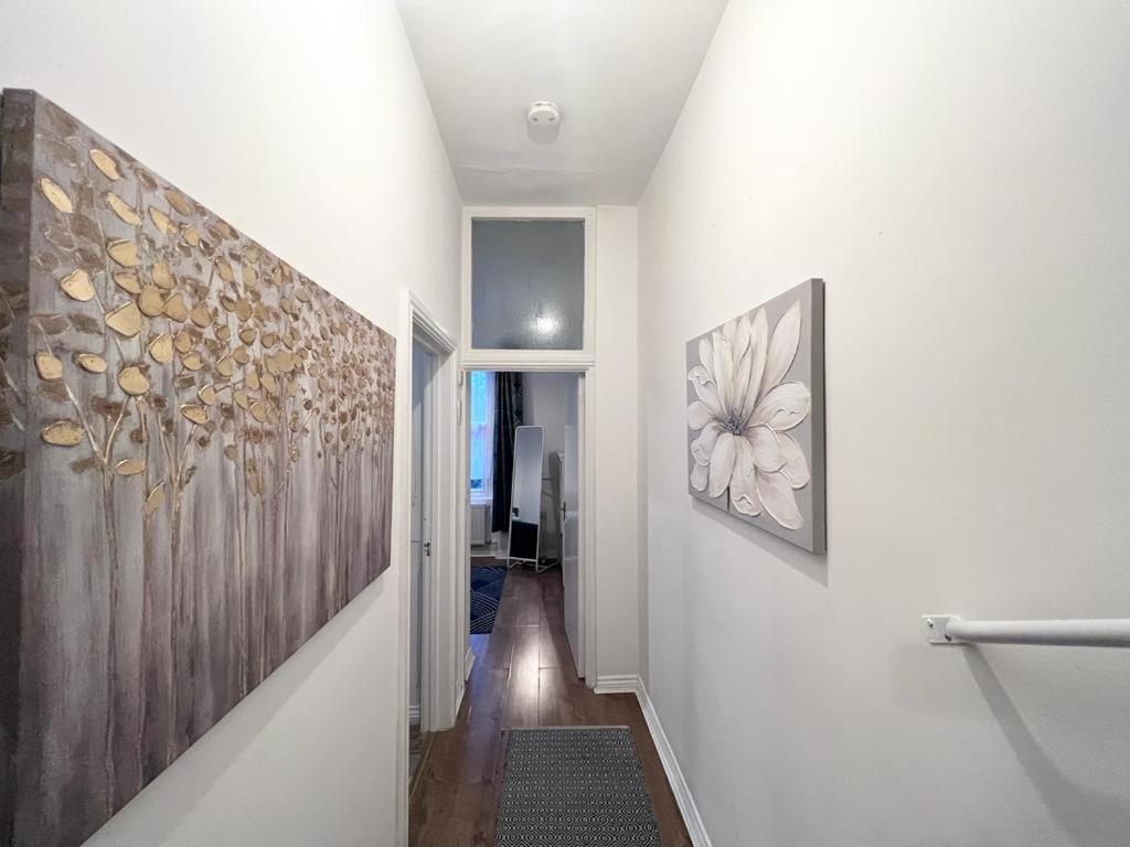 a hallway with two paintings on the wall at Yeovil Apartments in Yeovil