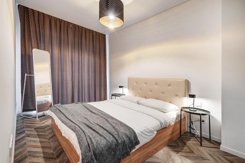 cohost I New Bastėja Life Apartments w-Garage Prkg & Self Check-in في فيلنيوس: غرفة نوم بها سرير كبير ومرآة