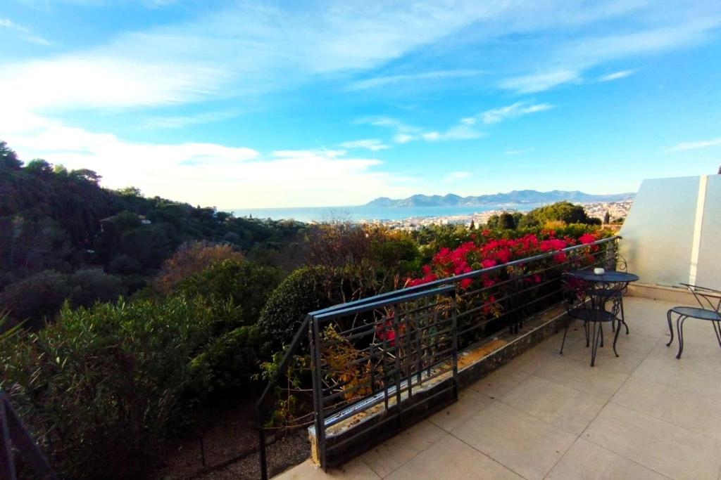 Elle comprend un balcon avec une table et des fleurs. dans l'établissement WE CANNES ! Sea View & Large Terrace LA VISTA, à Cannes