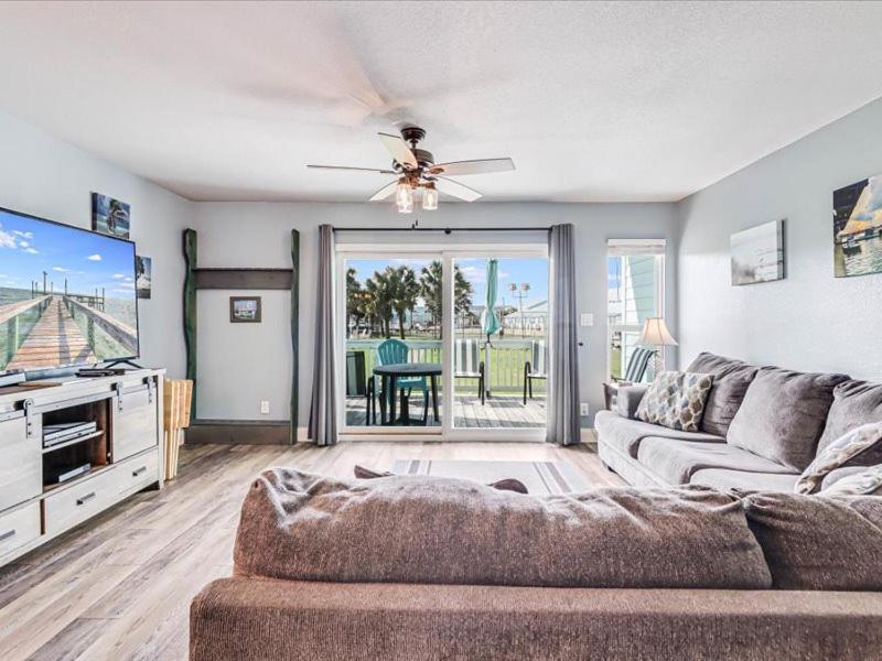 a living room with a couch and a flat screen tv at Bayfront Kontiki 704 in Rockport