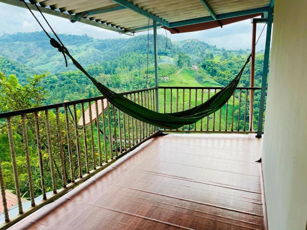 een hangmat op een balkon met uitzicht op de bergen bij EL EDEN HABITACIONES in Manizales