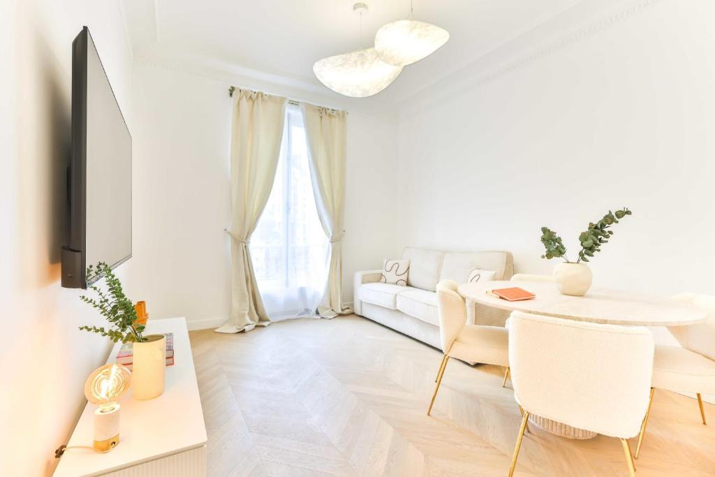 un salon blanc avec un canapé blanc et une table dans l'établissement Charming 2BR - 6P - Eiffel Tower, à Paris