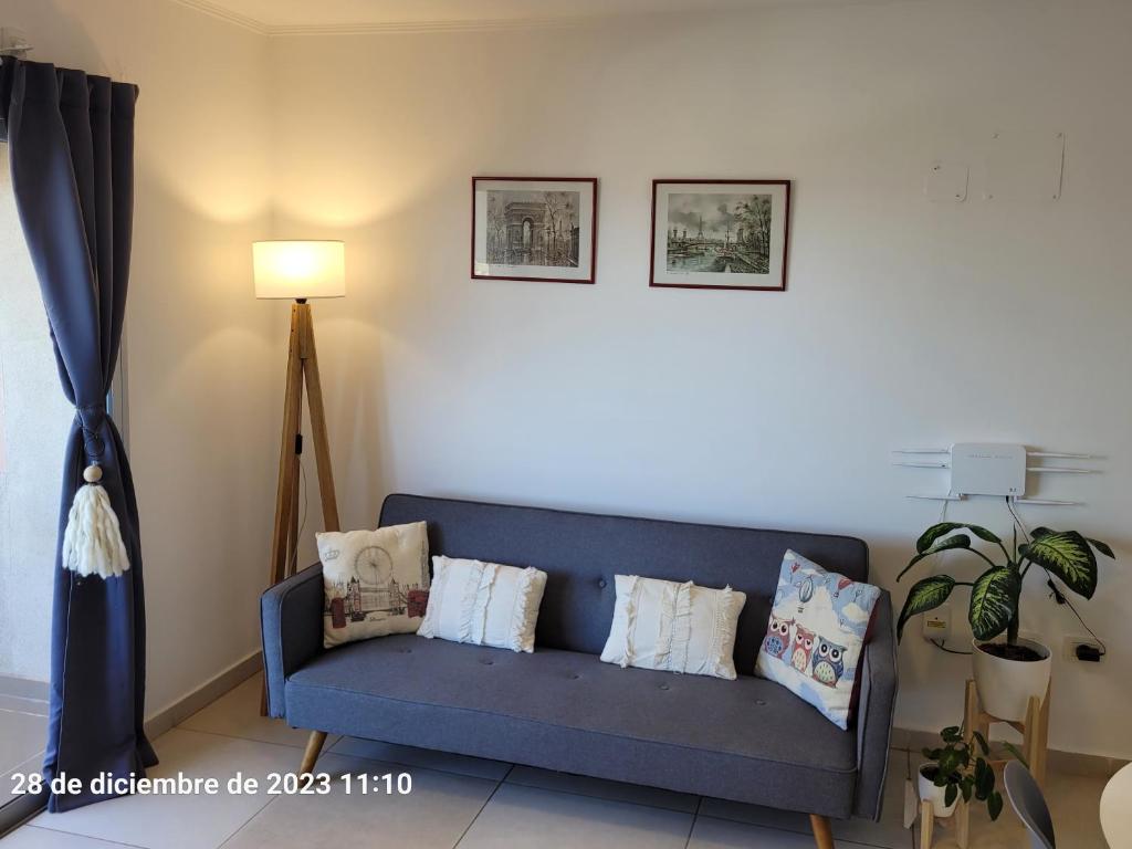 a living room with a blue couch with pillows at Departamento centrico en Posadas in Posadas