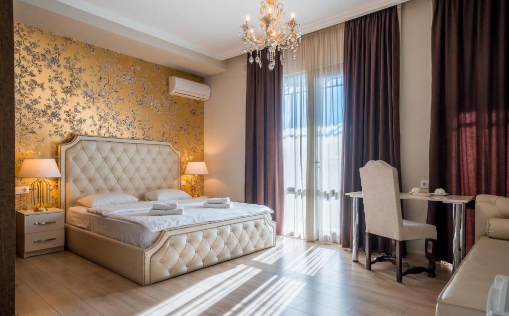 a bedroom with a bed and a desk and a chair at Rivendell Boutique By Umbrella in Tbilisi City