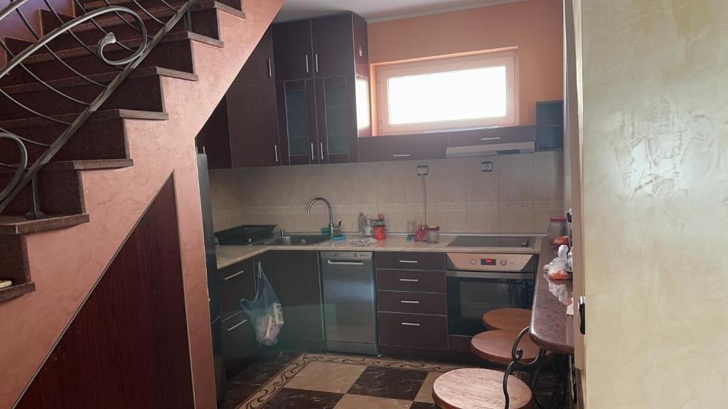 a kitchen with brown cabinets and a sink and a window at 朋来house in Ledine