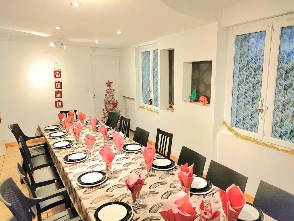 a long table with red napkins and chairs in a room at L'auberge Angevine in Angers