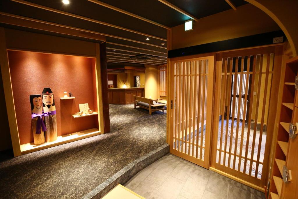 una habitación japonesa con una habitación con puertas y una habitación con una habitación en Nakajimaya Ryokan, en Nozawa Onsen