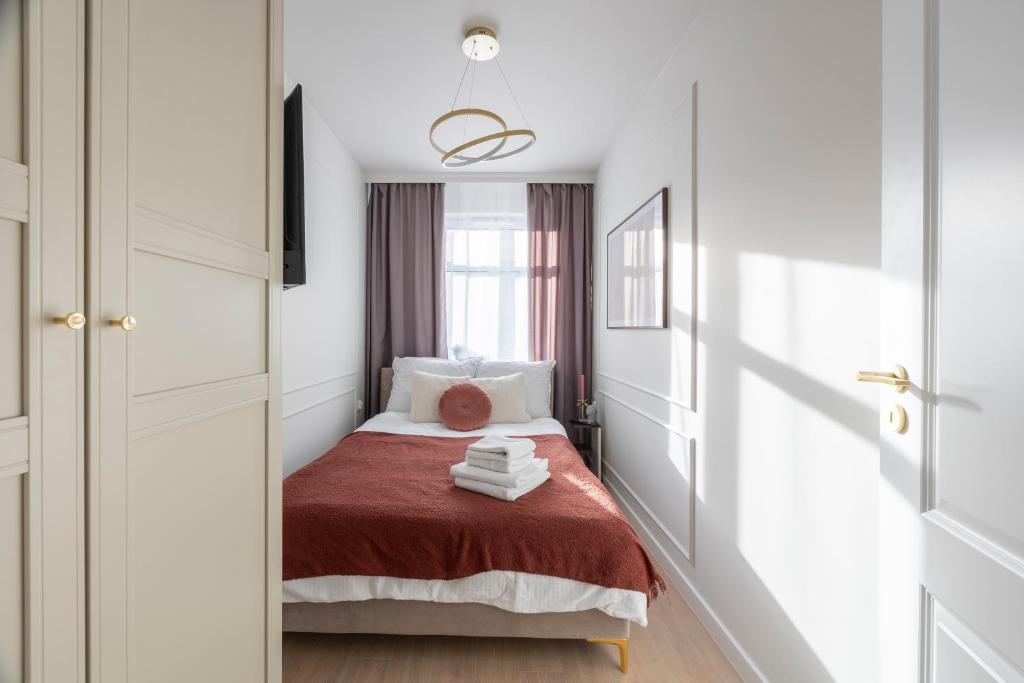een kleine slaapkamer met een bed en een raam bij Comfy Aparts Plac Solny in Głogów