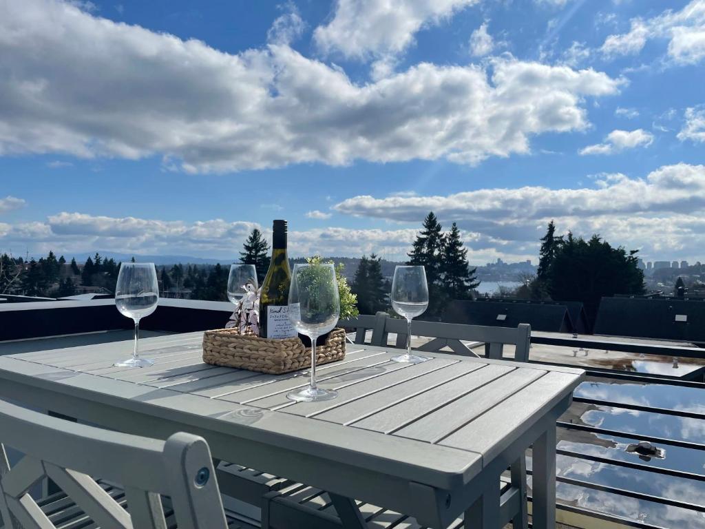 a table with wine glasses and a basket on a balcony at Winslow Place BY Betterstay in Seattle