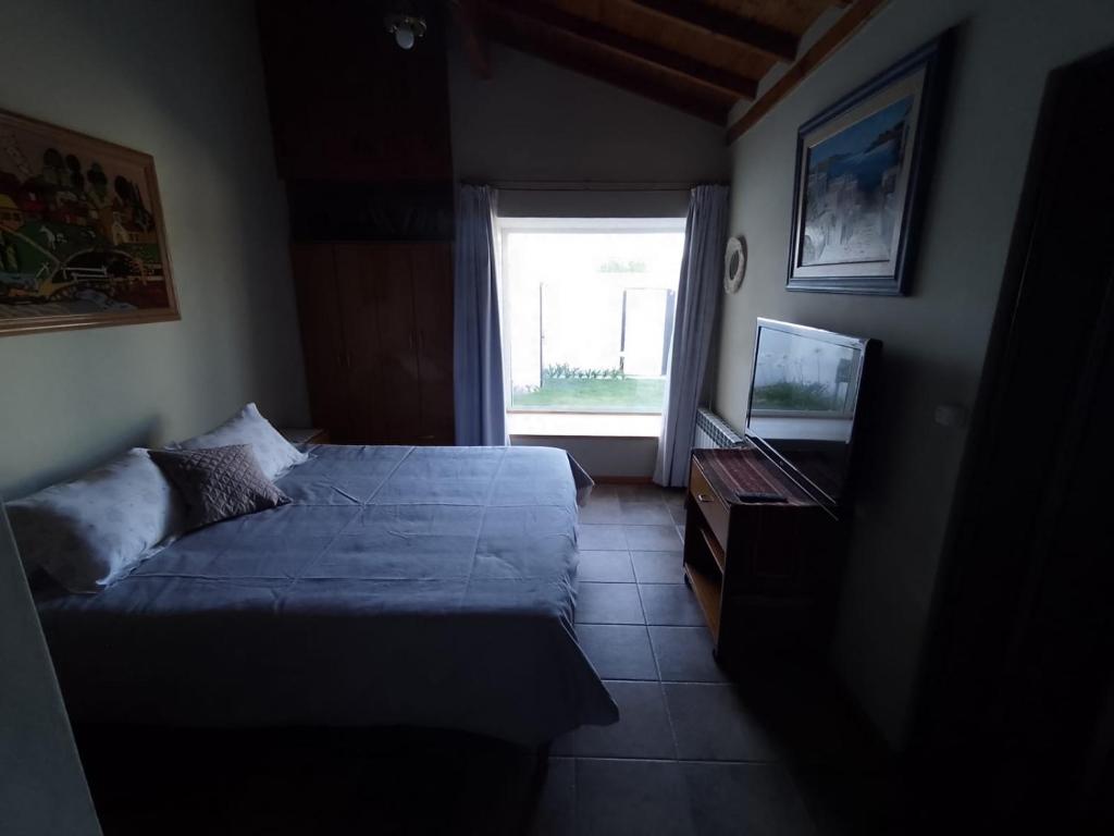 a small bedroom with a bed and a window at La Laguna - Casa familiar a 5 cuadras de la playa. in Puerto Madryn