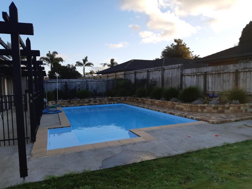 a swimming pool in a backyard with a fence at Kerikeri Central House in Kerikeri
