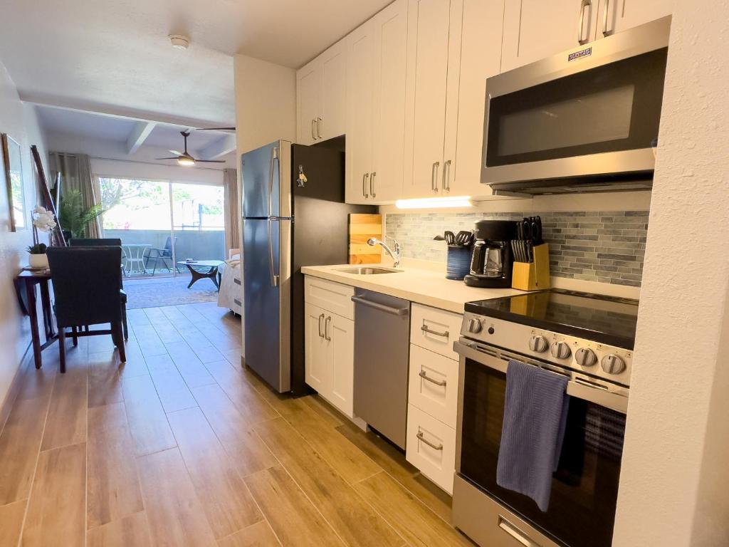 a kitchen with a sink and a stove top oven at Kihei Bay Surf 130- Garden View Studio, FREE PARKING in Kihei