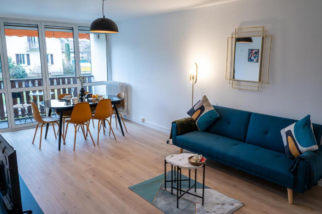 sala de estar con sofá azul y mesa en Magnifique Appartement de 3 chambres, en Annecy