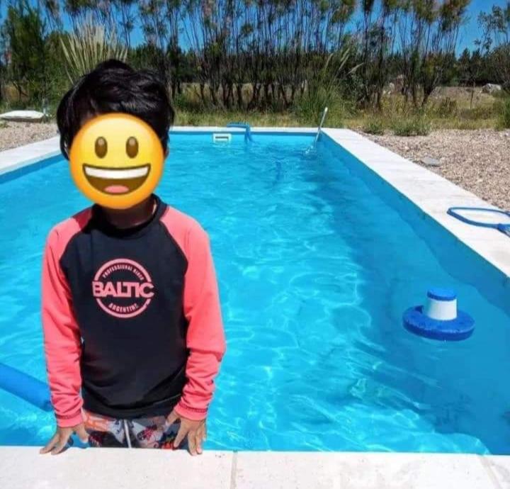 a young boy standing in front of a swimming pool at Los tordos posada in Puerto Madryn