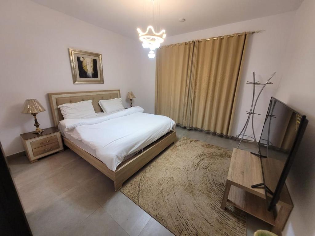 a bedroom with a bed and a television in it at رويال فيلا بمسبح خاص in King Abdullah Economic City