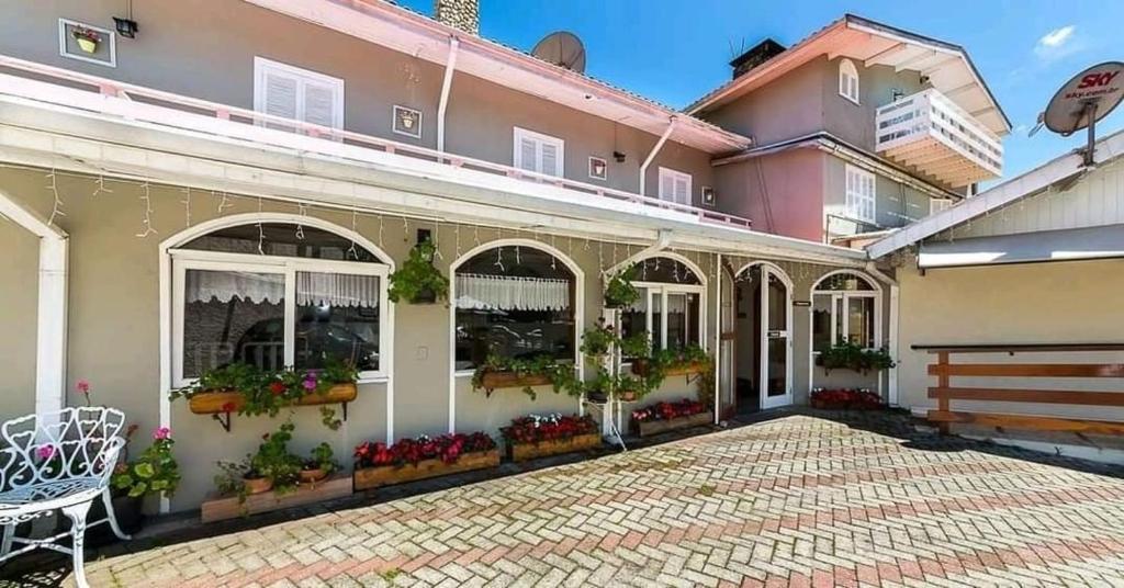 a house with flowers in the windows of it at Siena Hotel in Campos do Jordão