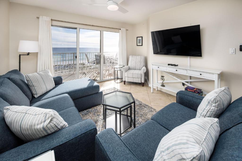 ein Wohnzimmer mit zwei blauen Sofas und einem TV in der Unterkunft Gulf Dunes 312 by Brooks and Shorey Resorts condo in Fort Walton Beach