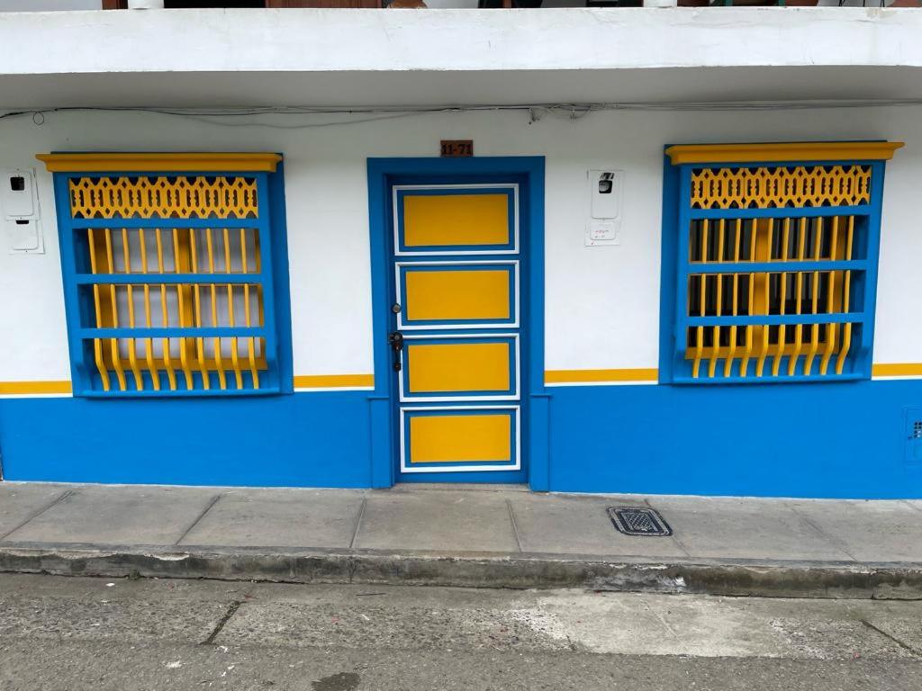 un edificio blu e bianco con finestre gialle e blu di Hotel Don Blas Jardín a Jardin