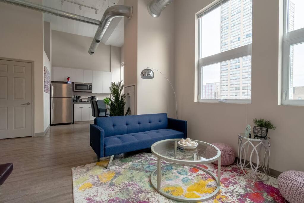 a living room with a blue couch and a table at McCormick 2br/2ba Oasis with optional Parking, Patio, Gym for up to 6 guests in Chicago