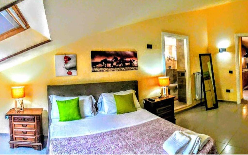 1 dormitorio con 1 cama grande con almohadas verdes en Residence Cuore, en Caserta