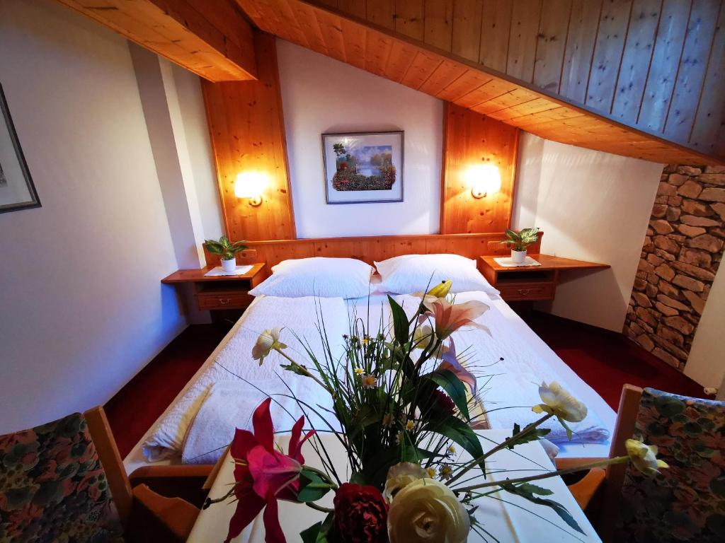 a bedroom with a bed and a table with flowers on it at Gasthof Geronimo in Weissbach bei Lofer