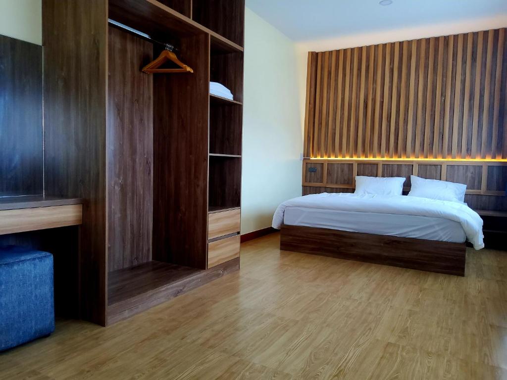 1 dormitorio con 1 cama y pared de madera en ฮิมต้งฮิมตาง HimtongHimtang, en Nan