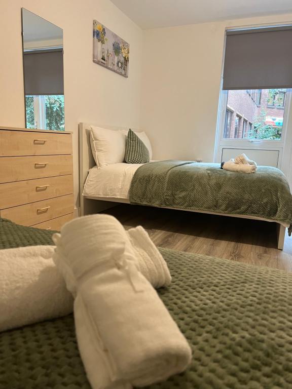 a bedroom with two beds and a dresser at Lovely Triple and Quadruple Bedrooms in Euston in London