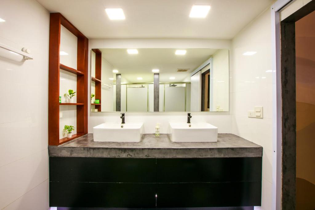 a bathroom with two sinks and a large mirror at Lafami Hostel in Ban Nongdouang