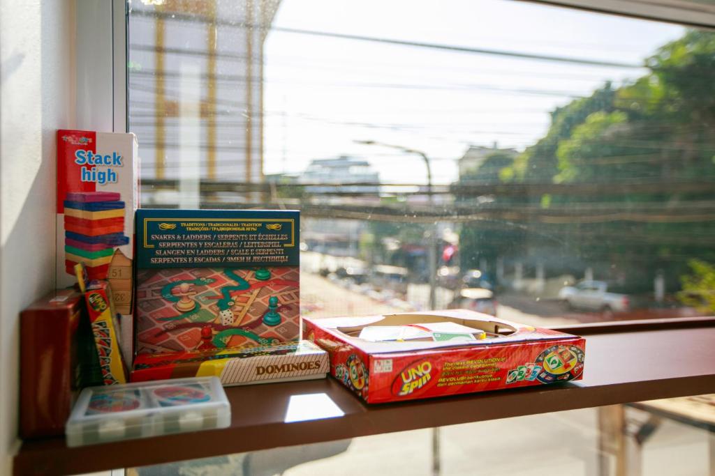 a shelf with books on a window sill at Lafami Hostel in Ban Nongdouang