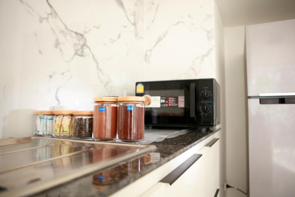 a kitchen counter with jars of jam next to a microwave at Lafami Hostel in Ban Nongdouang