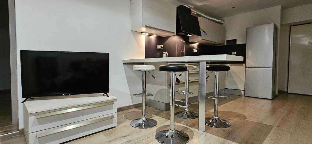 uma cozinha com televisão e um bar com bancos em il Cortiletto 2 apartments em Calolziocorte