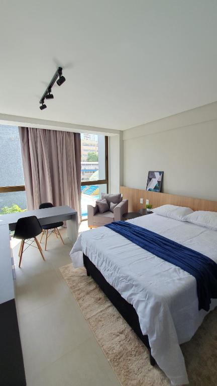 a bedroom with a large bed and a desk at Flat Novo em Boa Viagem - Rooftop 470 in Recife