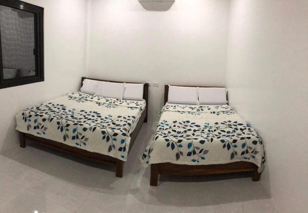 twee bedden naast elkaar in een kamer bij Bohol villa in Dauis