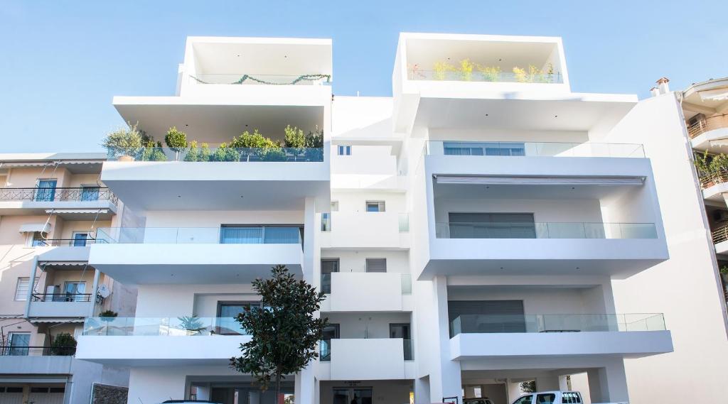un edificio de apartamentos blanco con balcones. en White luxury apartment, en Tríkala