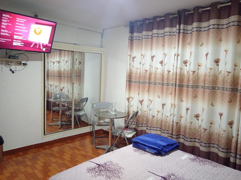 una camera con letto, tavolo e televisore di Bello y acogedora casa -departamento habitaciones a Lima