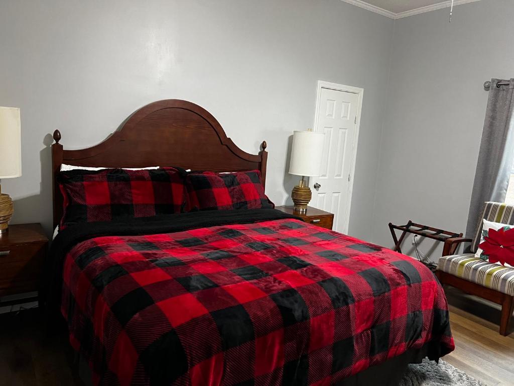 1 dormitorio con 1 cama con manta roja y negra a cuadros en Country Club, en Wadley