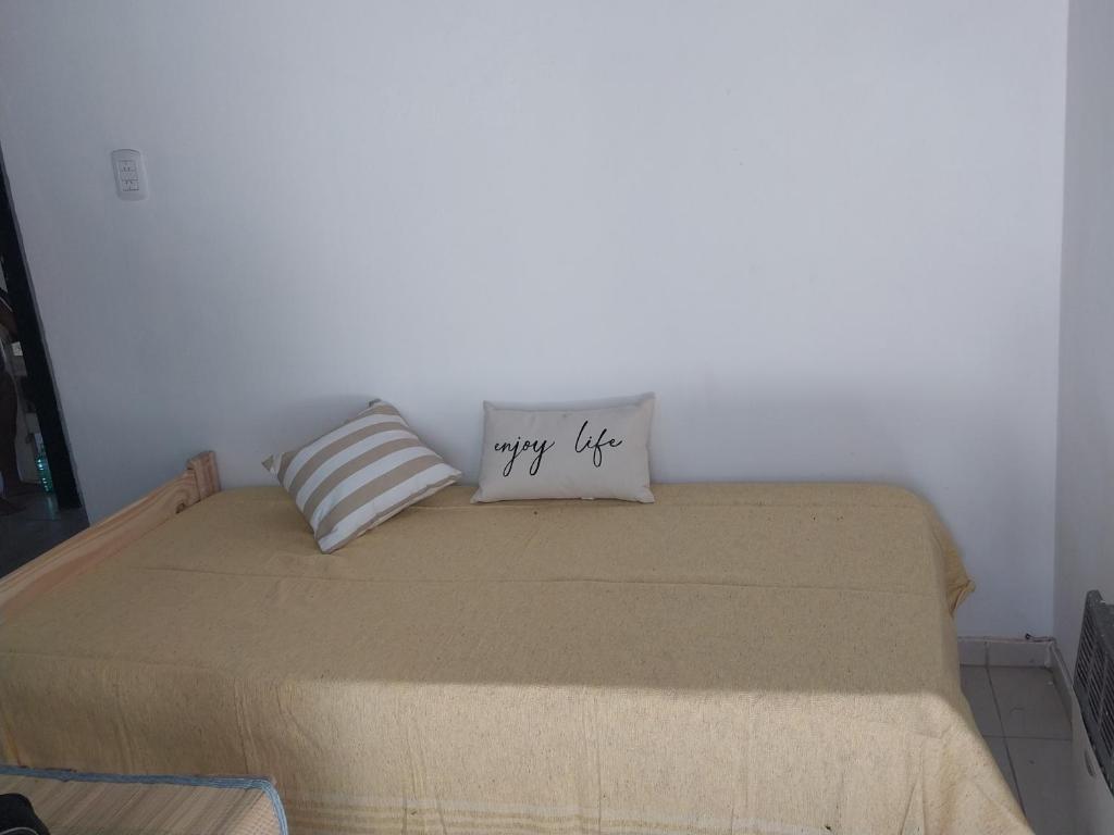a bed with a happy life pillow on top of it at Casa la buena vida in San Rafael