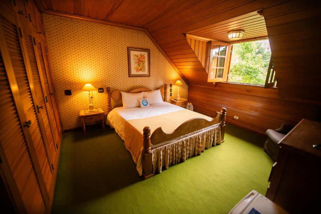 een slaapkamer met een bed en een raam bij Pousada C Turismo in Campos do Jordão