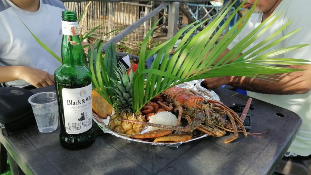 een tafel met een fles wijn en een ananas bij hoel joss in Moñitos