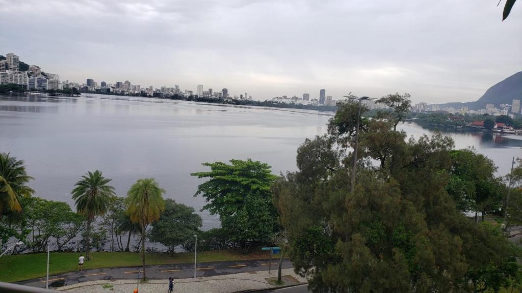 uma grande massa de água com uma cidade ao fundo em Apartamento Frente Lagoa - RJ no Rio de Janeiro