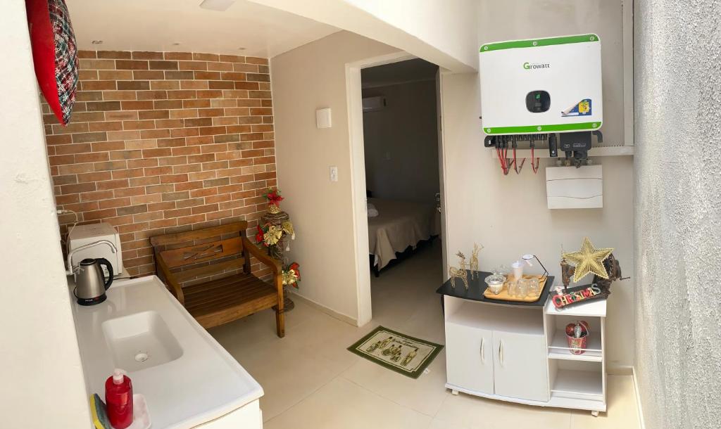 a small kitchen with a sink and a brick wall at Apartamento 01 Le Sorelle in Rosário do Sul