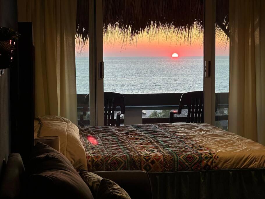 a bedroom with a bed and a view of the ocean at Brisa Del Mar #1 in Puerto Escondido
