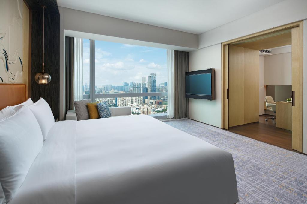 InterContinental Zhuhai, an IHG Hotel في تشوهاى: غرفة فندقية بسرير كبير ونافذة كبيرة