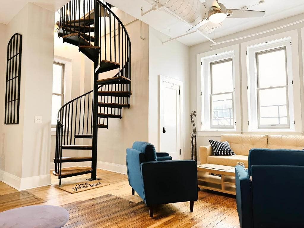 a living room with a spiral staircase and a couch at The Historic Lyric Penthouse with Private Rooftop in Cincinnati