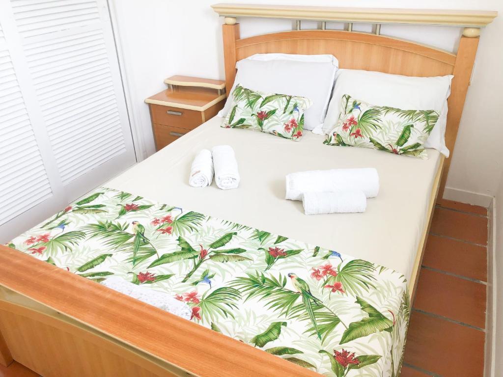 una camera con letto e copriletto tropicali di Apartamento de 3 quartos em Jurerê a Florianópolis