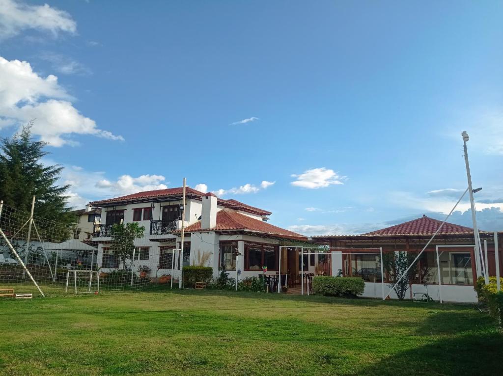 ein Haus mit grünem Rasen davor in der Unterkunft Hotel Casa Campestre Villa Anita in Villa de Leyva