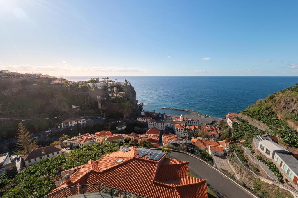 a town on a hill next to the ocean at Casa Coelho in Ponta do Sol