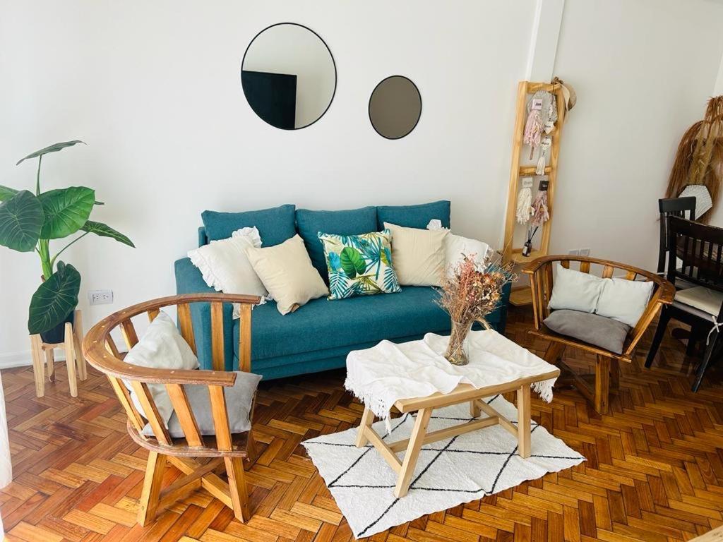 sala de estar con sofá azul y mesa en Departamento 3 ambientes con patio, terraza y parrila en Buenos Aires