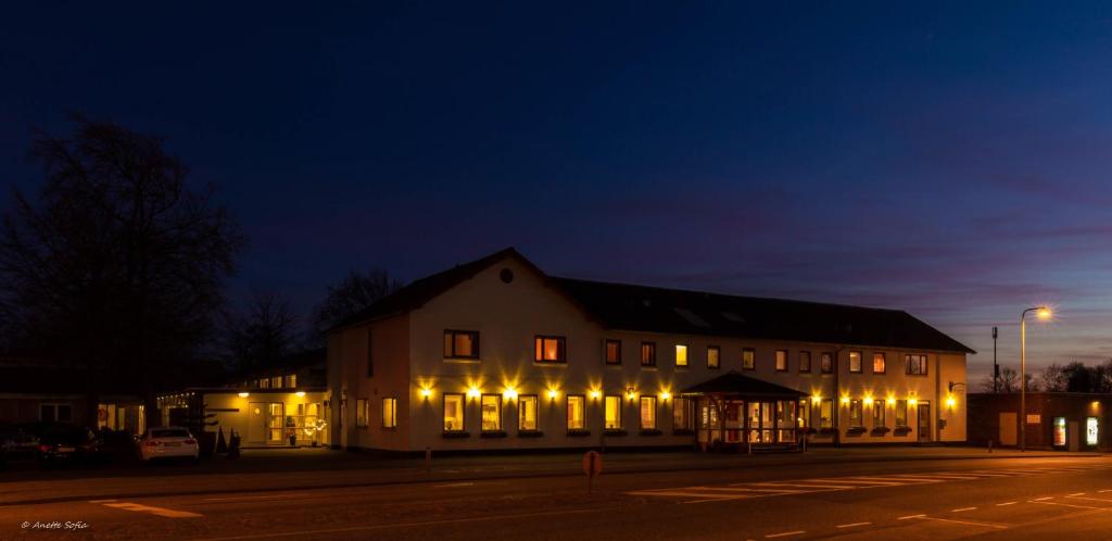 un edificio iluminado por la noche con luces en Sdr. Omme Kro & Hotel, en Sønder Omme